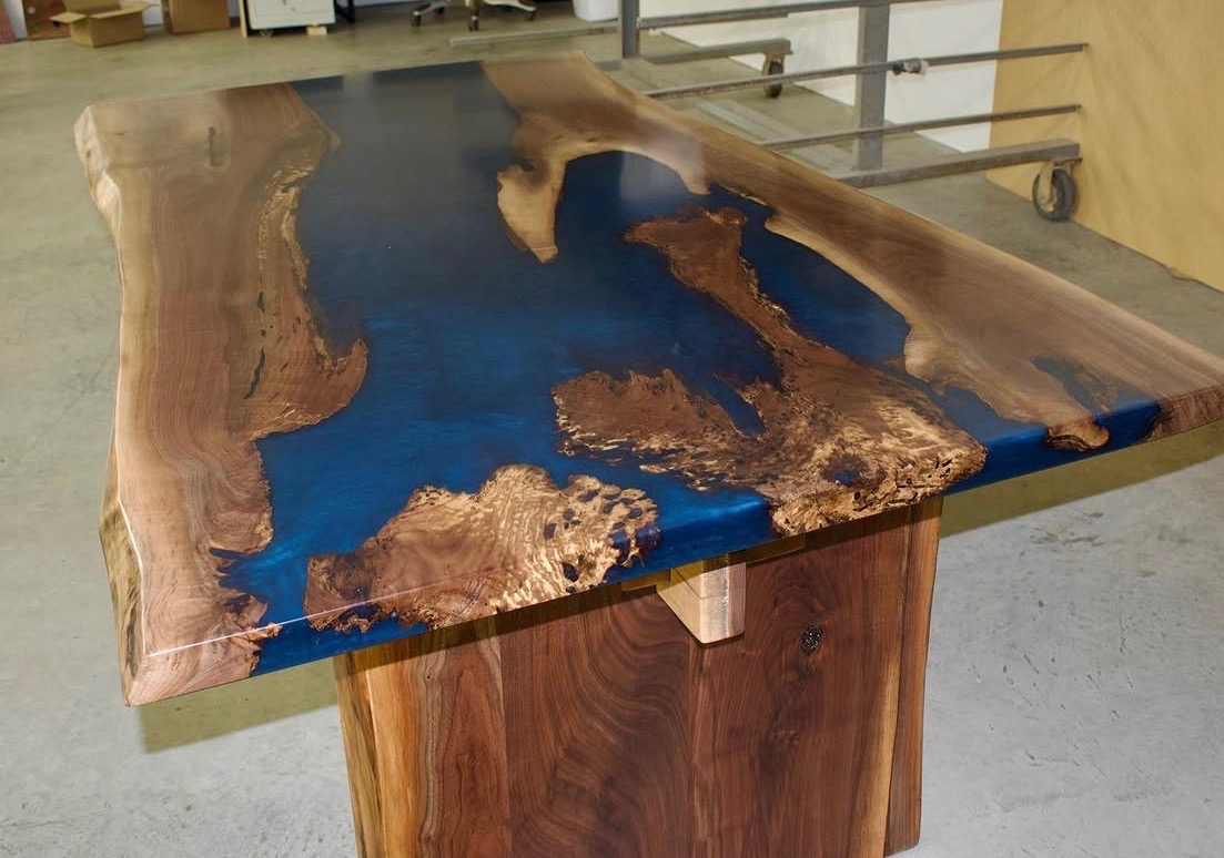 Walnut dining table with deep blue resin pools, full view