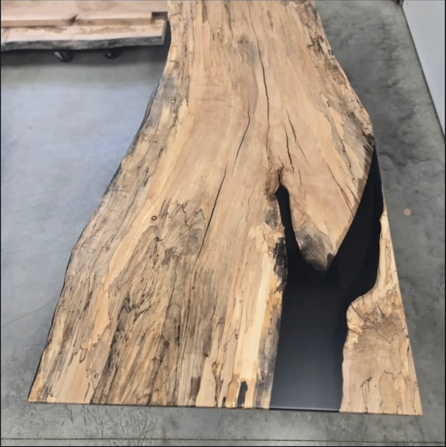 Spalted maple live-edge slab with black resin river, shop floor